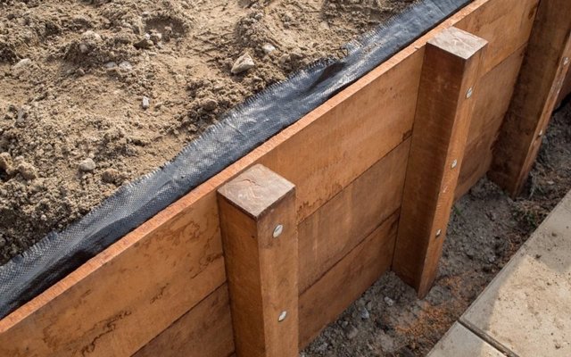 Een houten beschoeiing: planken, palen en gordingen
