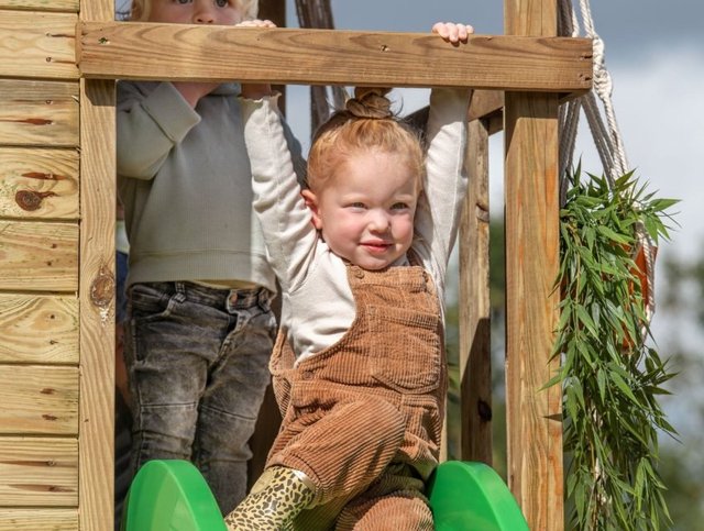 Twee kinderen op een houten speeltoestel